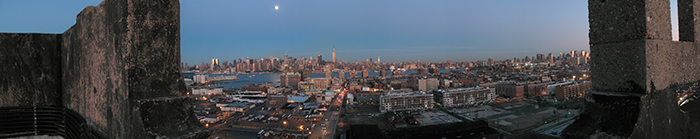 dusk, moonrise in gray blue sky. lights coming up in hoboken and manhattan