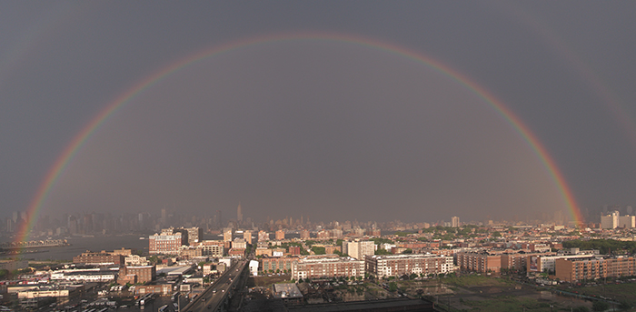 double rainbow in gray sky with strong afternoon light on hoboken and manhattan